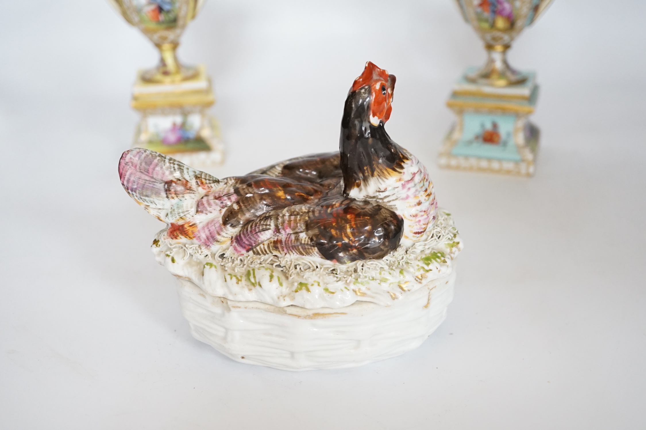 A pair of Dresden porcelain vases and covers (restored) together with a hen egg basket and cover, largest 19cm high (3)